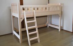 a wooden bunk bed sitting on top of a hard wood floor next to a ladder