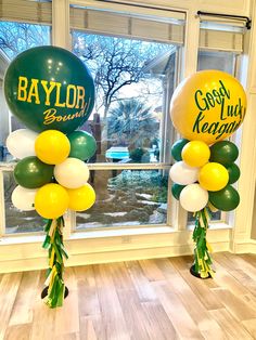 balloons in the shape of footballs are on display near a window at a school