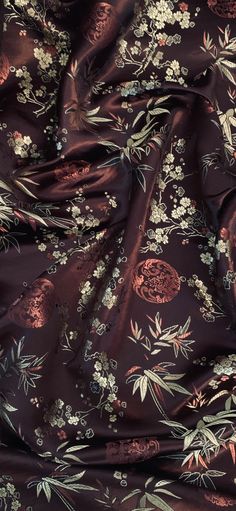 an image of a floral print fabric with flowers and leaves on the side, in dark brown