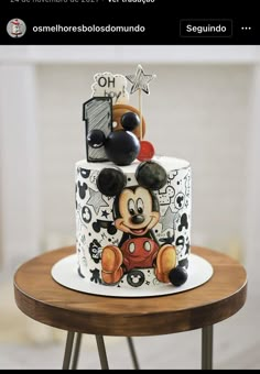 a mickey mouse cake on a table with other items in the top tier and bottom tier