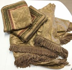 several pieces of cloth are laying on a white surface with fringes and tassels