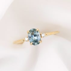 a ring with an oval cut blue topazte surrounded by three diamonds