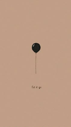 a black balloon with the words let it go written on it's side, in front of a pink background