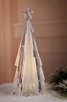 a clear glass christmas tree sitting on top of a table