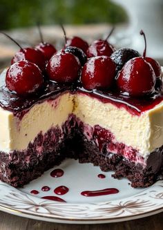 a cheesecake with cherries on top is cut in half and sits on a plate