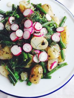 a white plate topped with potatoes, radishes and green beans