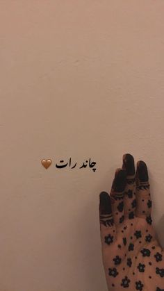 someone's hand with arabic writing on it and the bottom half of their foot