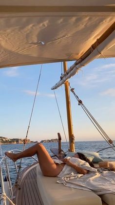 a woman laying on the deck of a sailboat