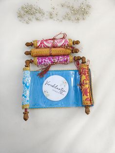 three decorative items are laying on a white surface next to beads and other things in the background