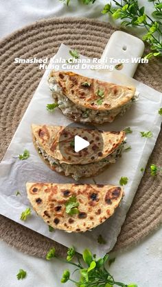 three flat breads on top of a paper towel next to some green leaves and flowers