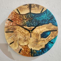 a clock made out of wood with blue and yellow paint on it's face