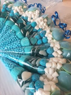 blue and white candies in cellophane wrappers on a table with ribbons