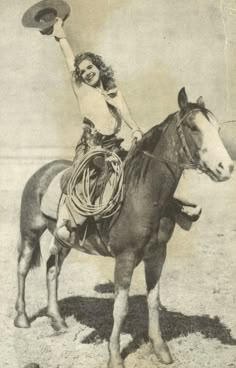 a woman riding on the back of a horse holding a frisbee in her hand