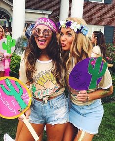 two girls are dressed up in costumes and holding paddles with cactus designs on them