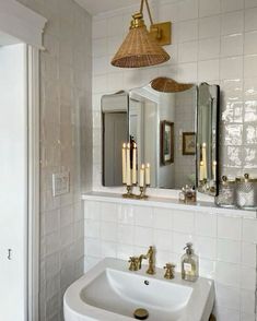 a white sink sitting under a bathroom mirror next to a wall mounted faucet