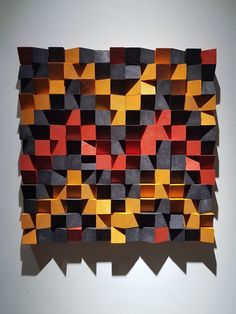 a piece of art that is made out of different colored pieces of wood and paper