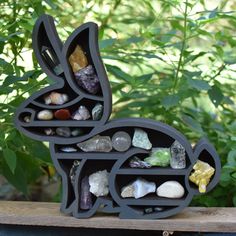 a rabbit shaped shelf with rocks and stones in it