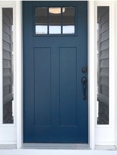 a blue front door with two sidelights on the top and bottom windows above it