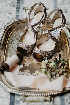 two pairs of shoes sitting on top of a silver tray