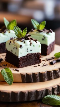 two pieces of cake on a wooden plate with mint sprinkles and chocolate chips