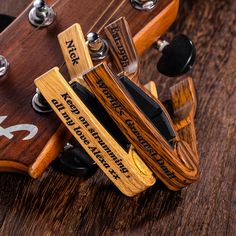 a close up view of an electric guitar's neck and headstock on a wooden surface