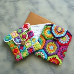 three crocheted wallets sitting on top of a marble counter next to each other