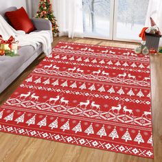 a living room with a couch and christmas decorations on the floor, along with a red rug