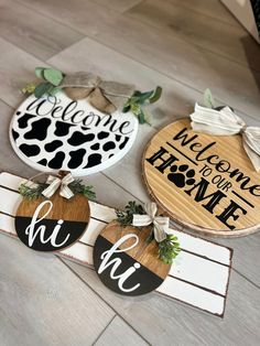 three wooden signs with the words welcome home and hi hi on them, sitting on a wood floor