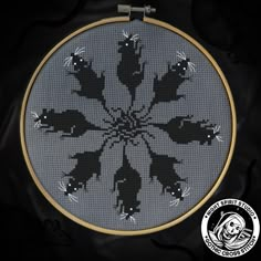 a cross stitch pattern with black and white flowers in the center on a gray background