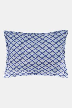 a blue and white pillow with an intricate design on the front, sitting on a gray background