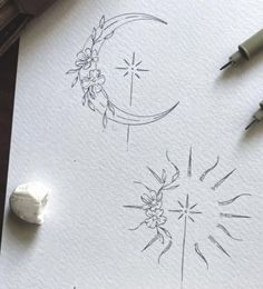 some inks are laying on top of a piece of paper with the moon and stars drawn