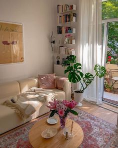 a living room with a couch, coffee table and bookshelf on the wall