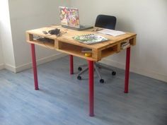 a desk with a laptop on it in an office space next to a chair and window