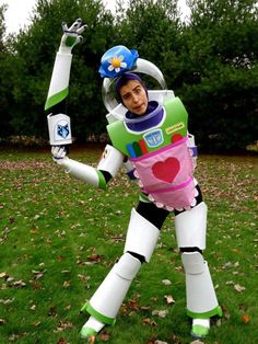 a man dressed as buzz lightyear from toy story in the grass with his arms outstretched