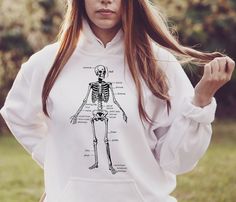 a woman with long hair wearing a white hoodie that has a skeleton on it