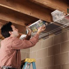 a man is working on the ceiling in his house with an air conditioner attached to it