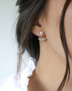 a close up of a person wearing some kind of earring with pearls on it