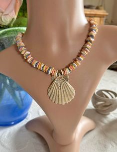 Step into the spirit of summer with our delightful necklace adorned with colorful seashell chips, accented by a charming small scallop shell centerpiece. The shell is meticulously washed and treated with a protective varnish, ensuring both durability and lasting beauty. Measuring approximately 40 cm (16 inches) with a 5 cm extension chain, this versatile piece perfectly captures the essence of the oceanic theme and is ideal for the summer trend of 2024.  Whether you're dressing up for a beach pa Multicolor Shell-shaped Jewelry For Beach, Multicolor Shell Jewelry For Vacation, Bohemian Multicolor Shell-shaped Jewelry, Multicolor Ocean-inspired Beach Necklaces, Ocean-inspired Multicolor Beach Necklaces, Multicolor Shell Necklace As A Gift, Multicolor Beaded Shell, Multicolor Vacation Shell-shaped Shell, Multicolor Shell-shaped Necklaces For Beach