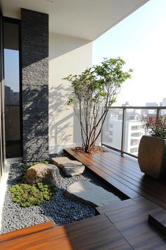 an outdoor area with rocks and plants on the ground, along with a wooden deck