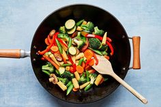 a skillet filled with vegetables on top of a blue table