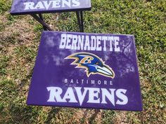 two baltimore ravens signs sitting on top of a lush green field