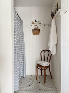 a chair sitting next to a shower in a bathroom