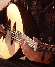 a man is playing an acoustic guitar outside