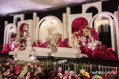 the stage is decorated with flowers and chandeliers for an elegant wedding or special event