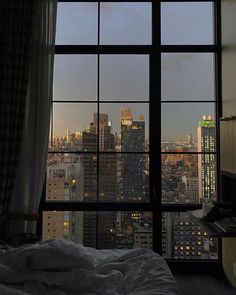 a bedroom with a view of the city at night