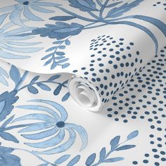 a blue and white floral wallpaper with polka dots on the bottom half of it