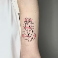 a small rabbit tattoo on the left inner arm and wrist, with stars around it