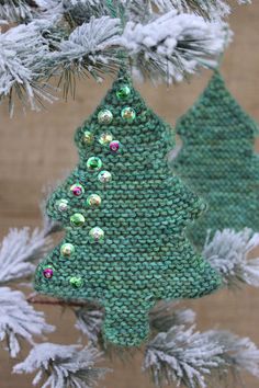 two green christmas trees hanging from a tree