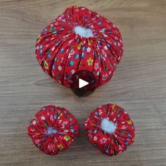 three pieces of red fabric sitting on top of a wooden table next to each other