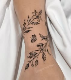 a woman's foot with flowers and leaves on it